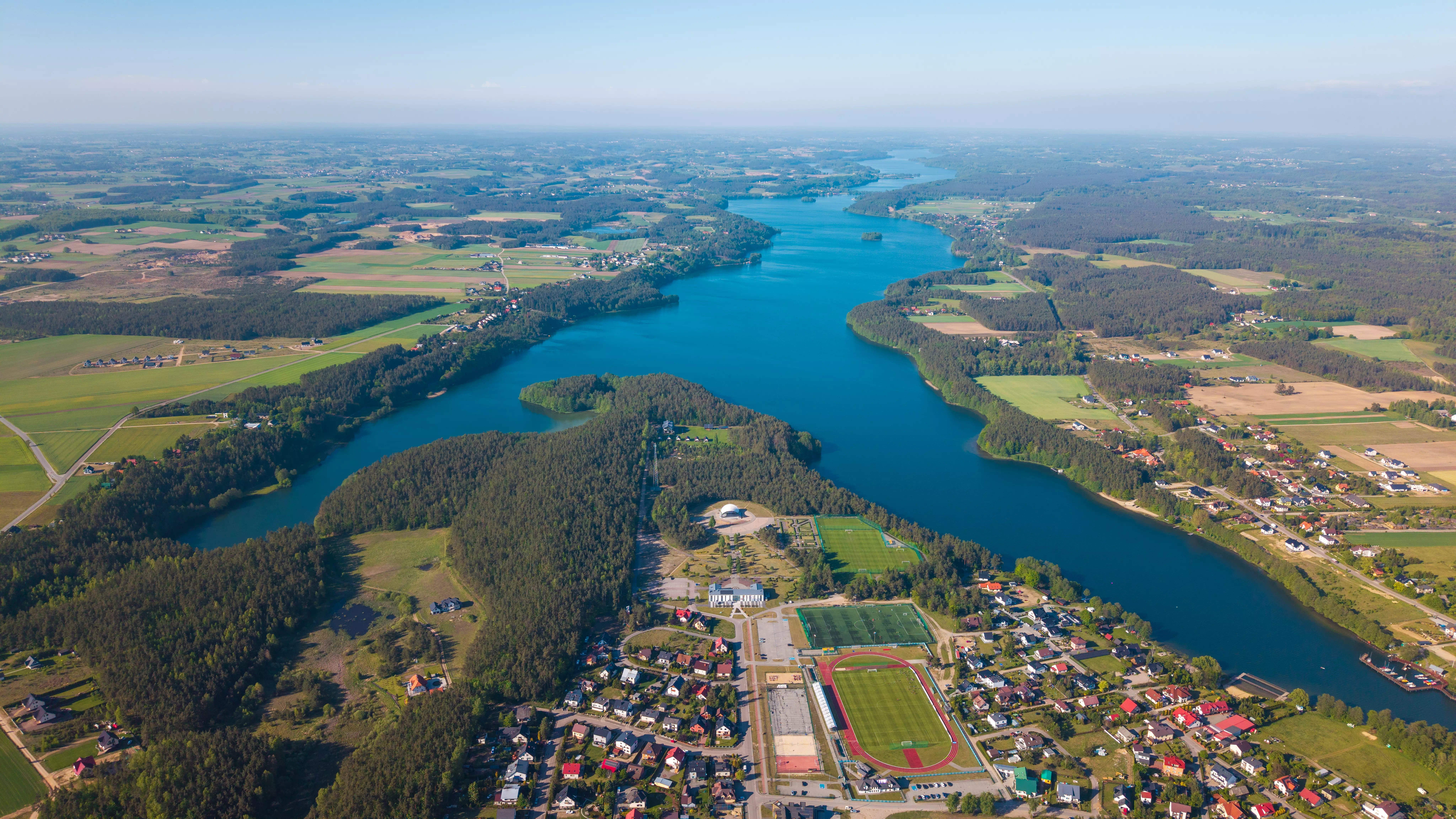 Szpital z dużym parkingiem i otaczającymi go budynkami mieszkalnymi, widok z powietrza