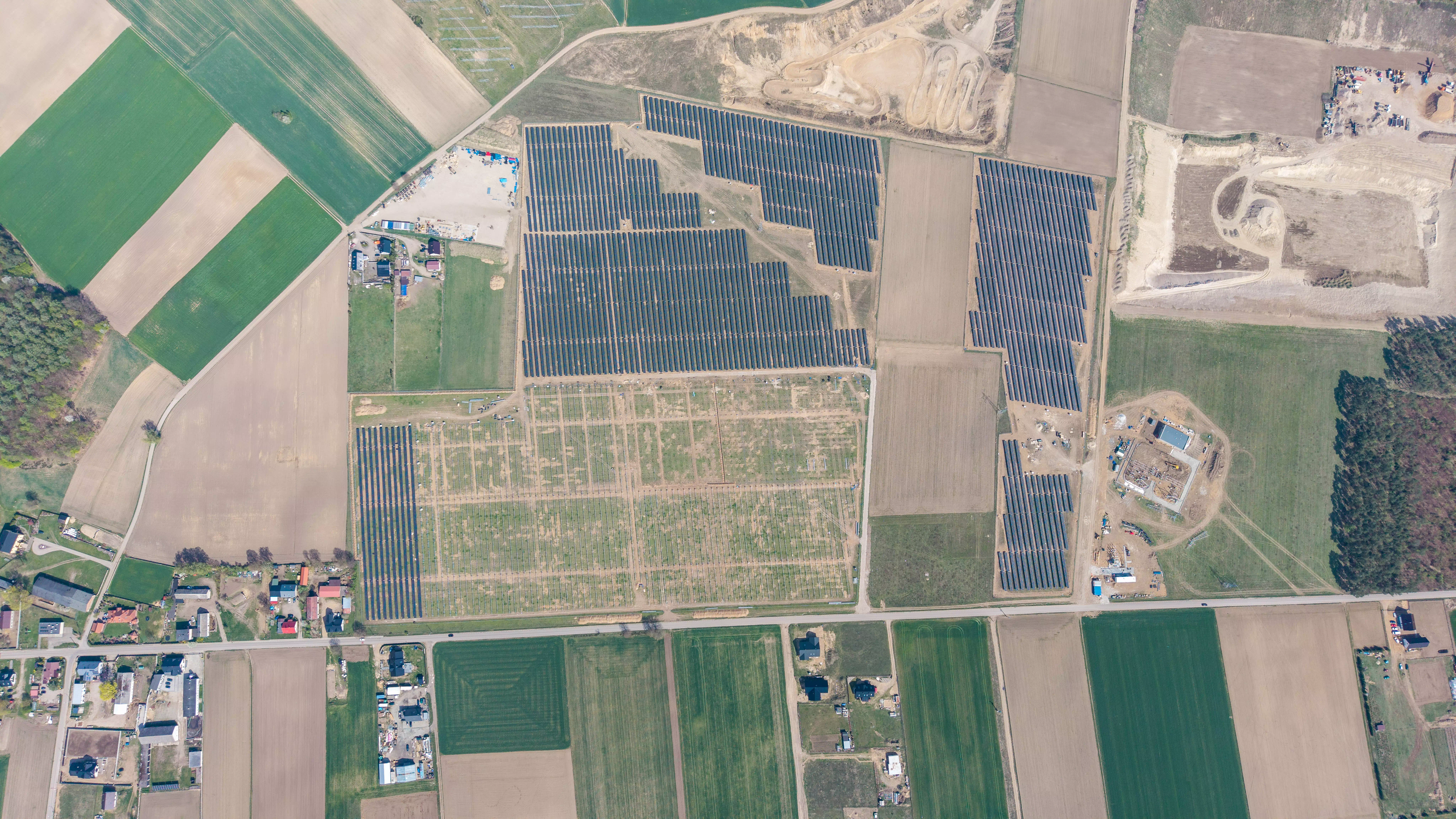 Centrum małego miasta z kościołem, halą sportową, domami i jeziorem, widok z lotu ptaka